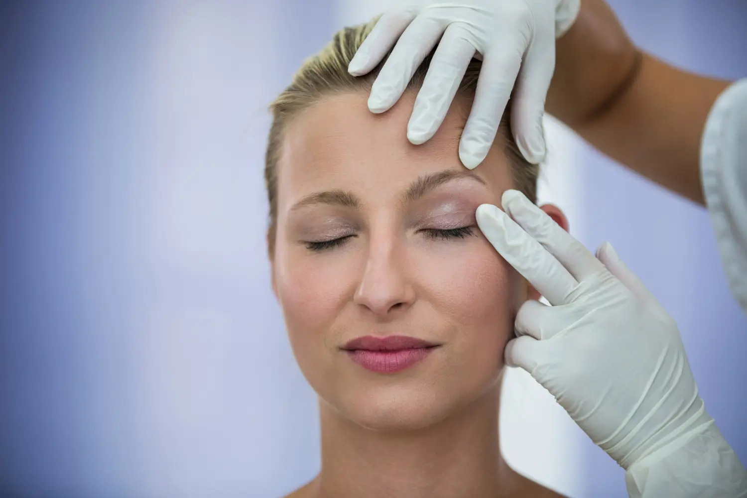 Médica examinando uma paciente feminina para realizar a cirurgia de cantoplastia dos olhos