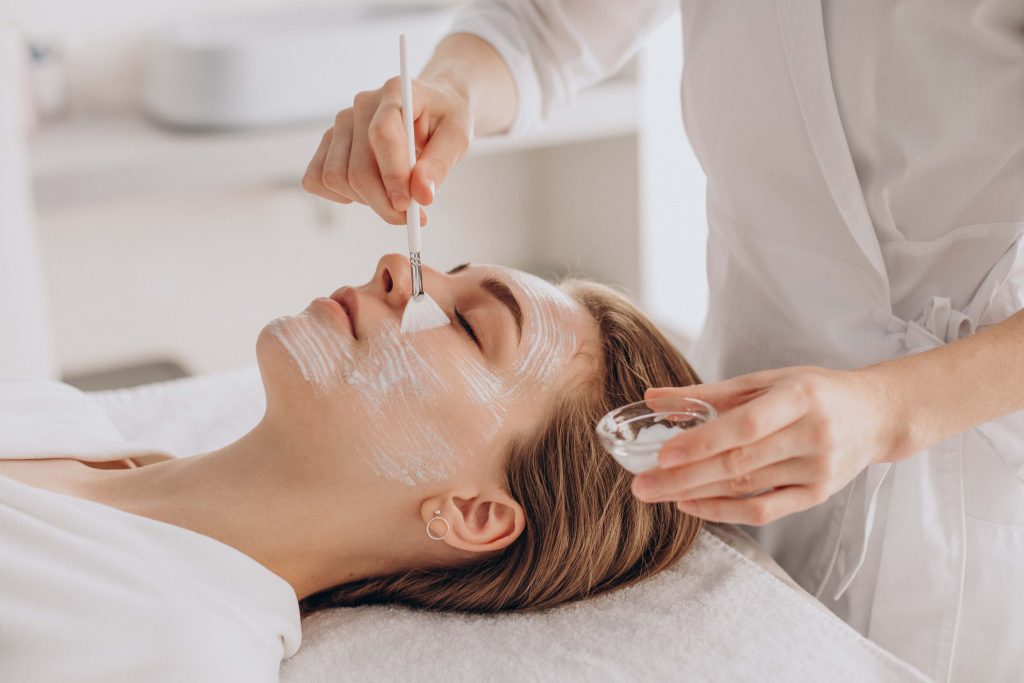 Profissional aplica produto no rosto de paciente durante um dos tipos de peeling